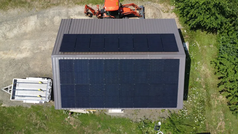 Low aerial of the outbuilding at the Acaciaville property carrying its own solar array