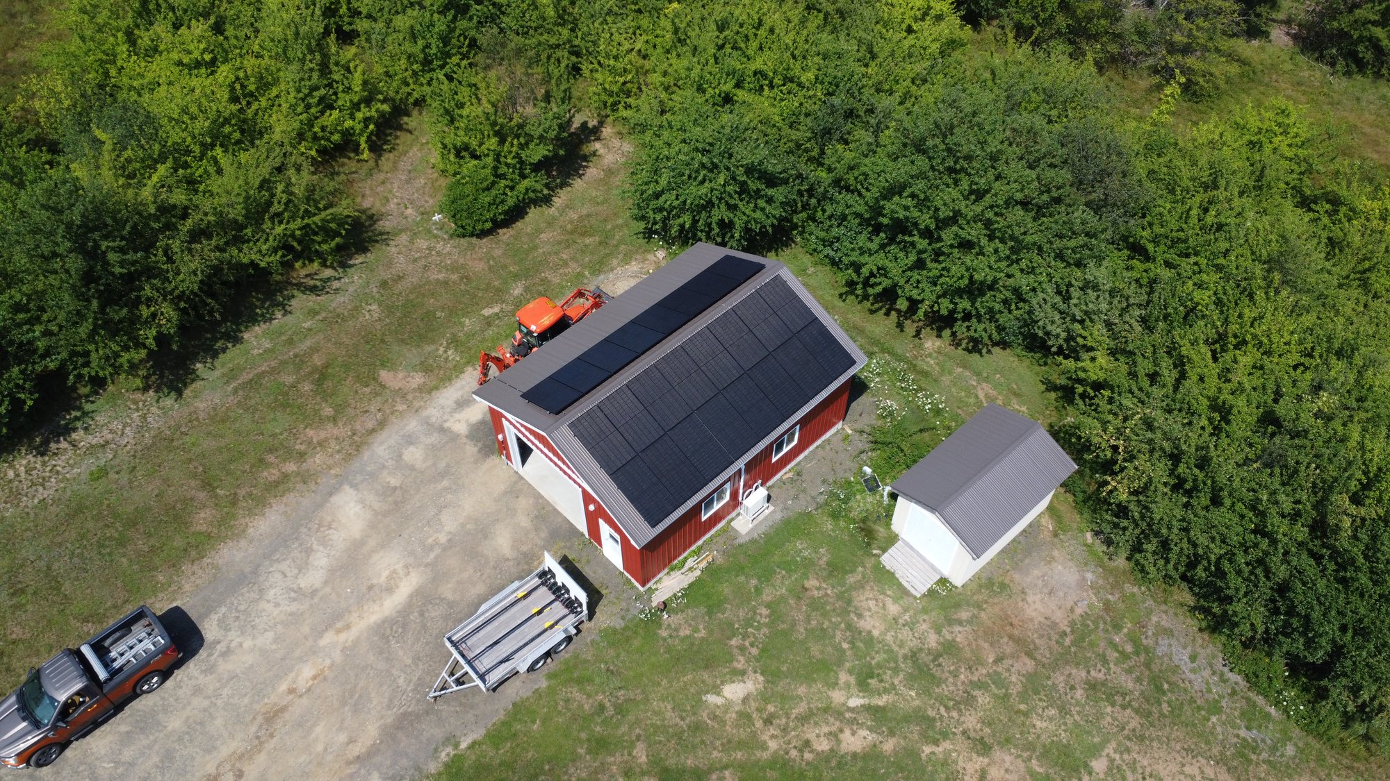 Aerial view of a red home in Acaciaville, Nova Scotia with a 12 kW rooftop solar array