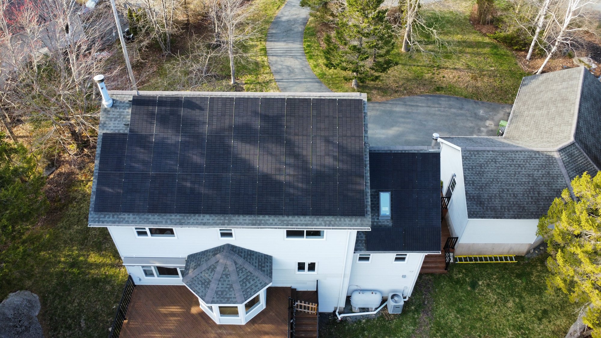 Aerial view of a white two-storey home in Hammonds Plains, Nova Scotia with a 15.84 kW rooftop solar array