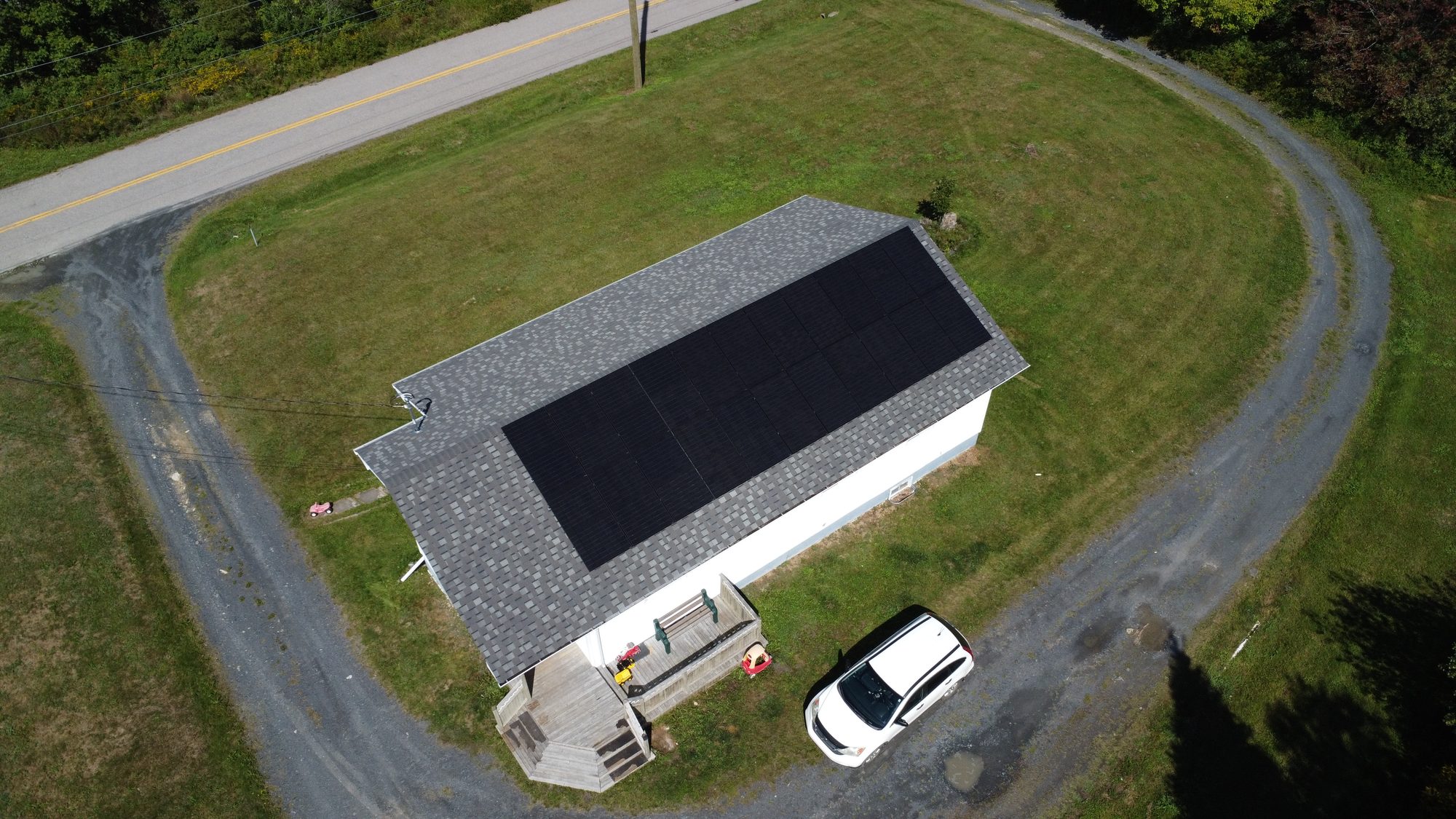 Aerial view of a white home in Marshalltown, Nova Scotia with an 11 kW solar array on its roof