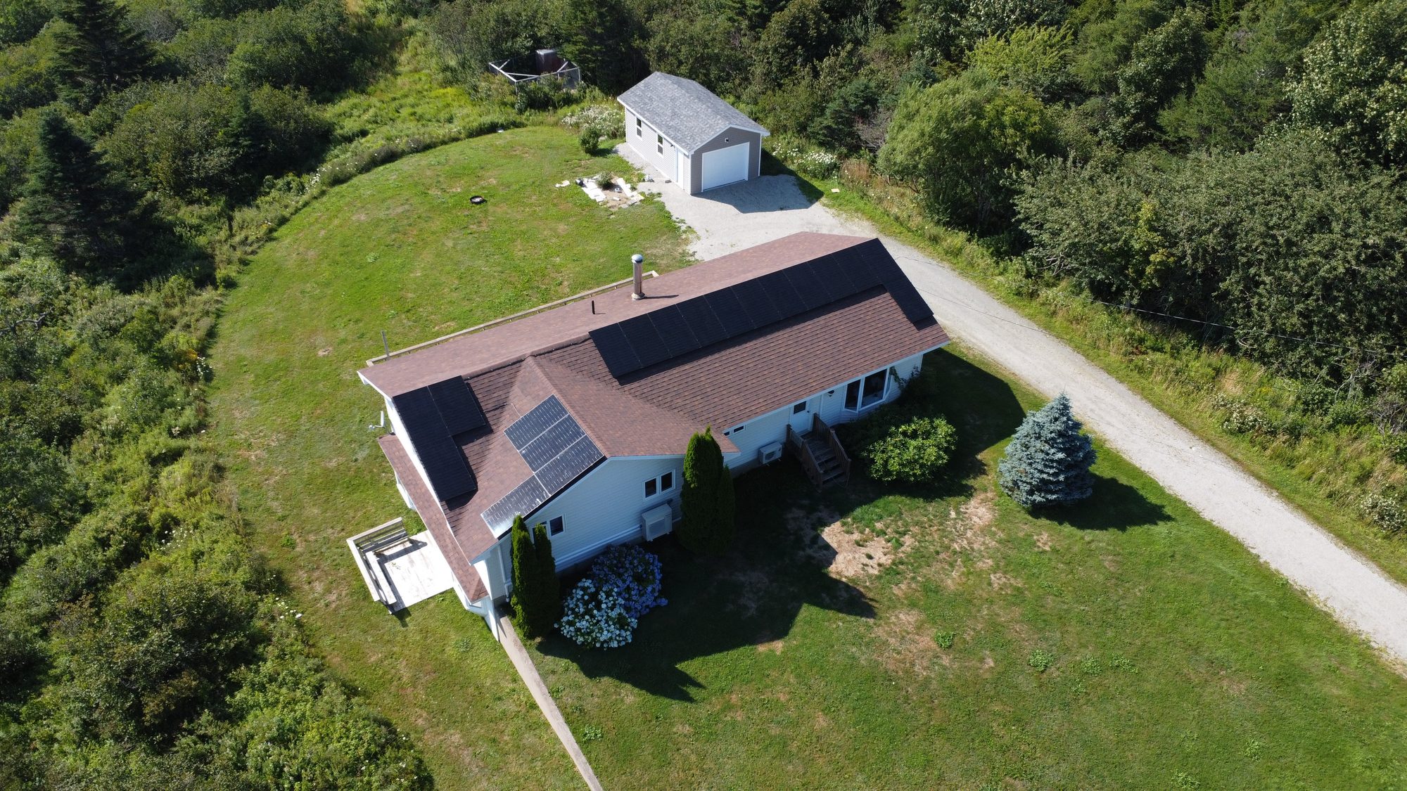 Aerial view of a home in Saint Alphonse, Nova Scotia with a 9.5 kW solar array split across two roof faces